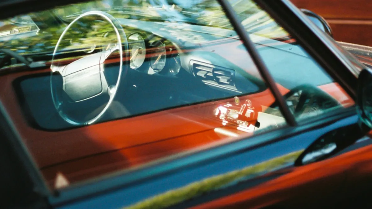 technician polishing a dark sedan in a clean professional bay