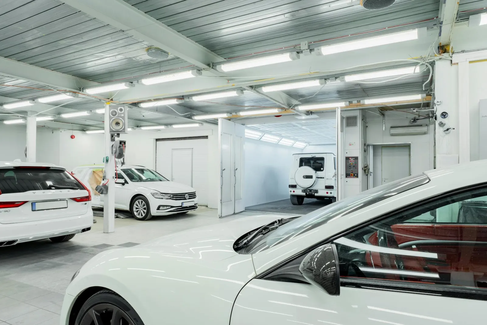 Technician applying ceramic coating inside a climate-controlled garage bay
