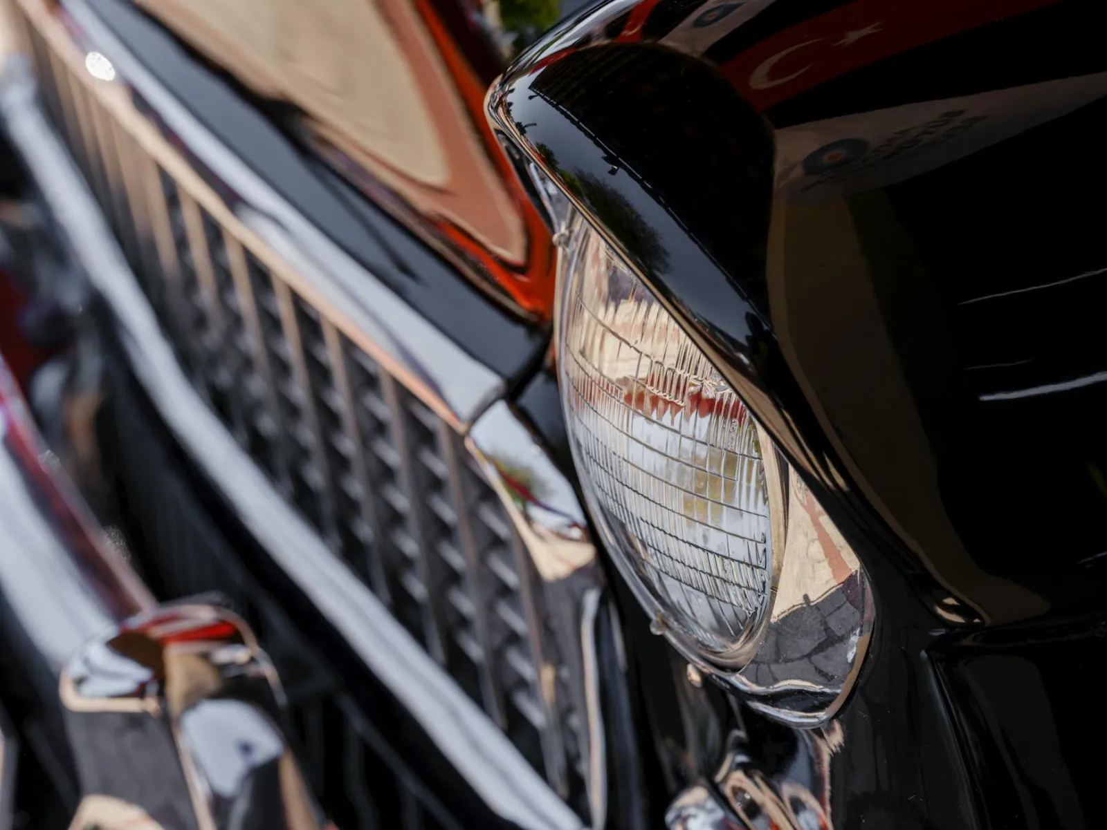 Close-up of swirl marks visible on dark car paint under direct lighting
