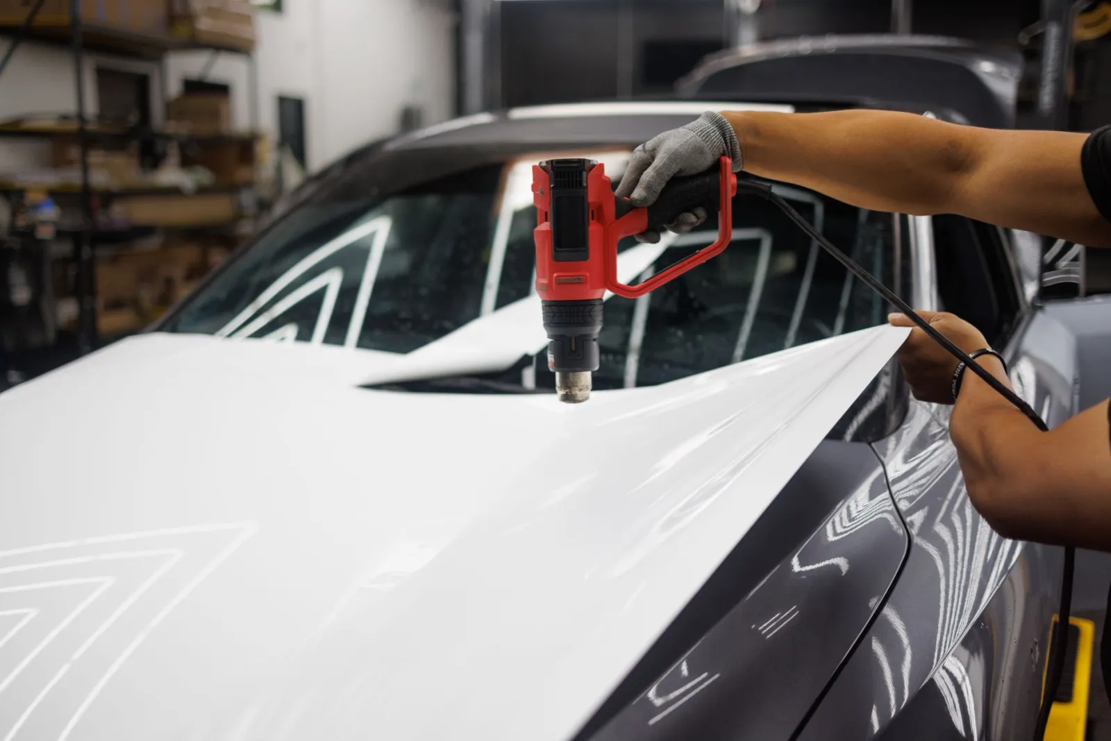 Close-up of clear paint protection film being applied to a vehicle hood