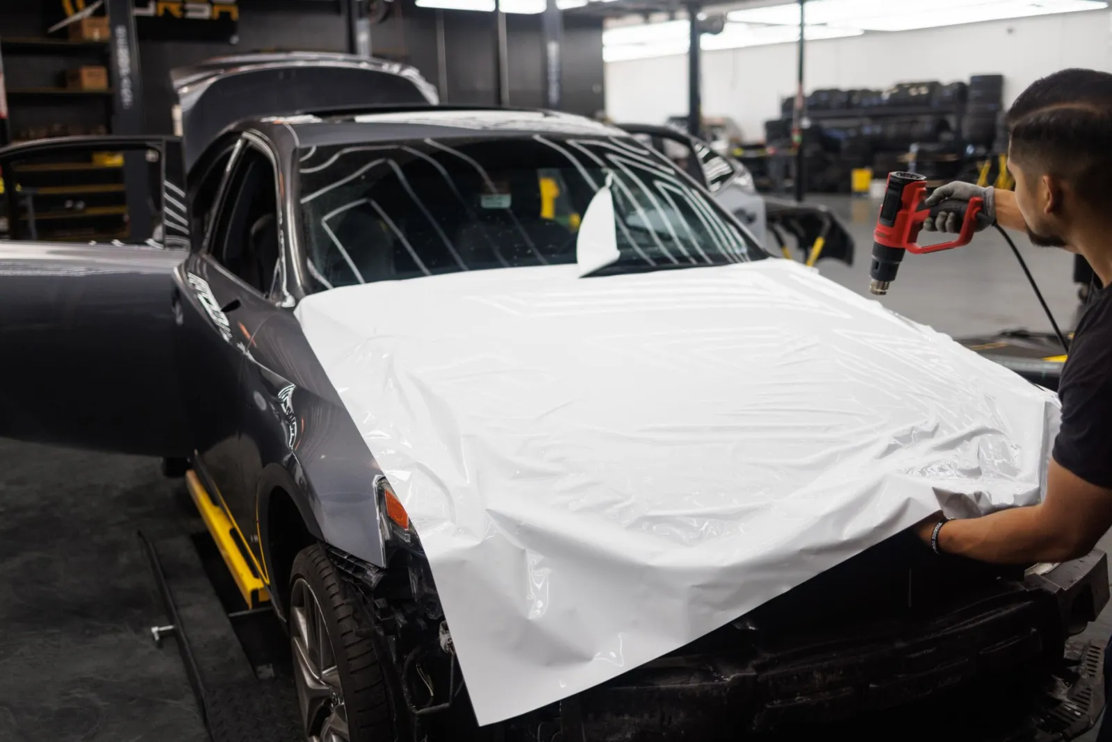 Close-up of clear protective film being applied to a vehicle hood