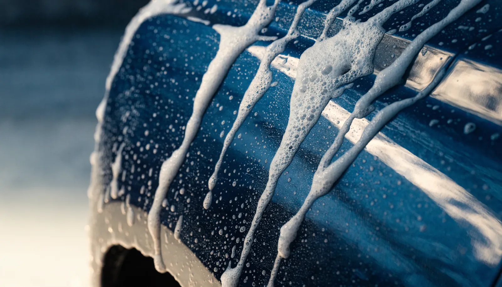 Thick white foam sheeting down the side of a glossy dark vehicle panel