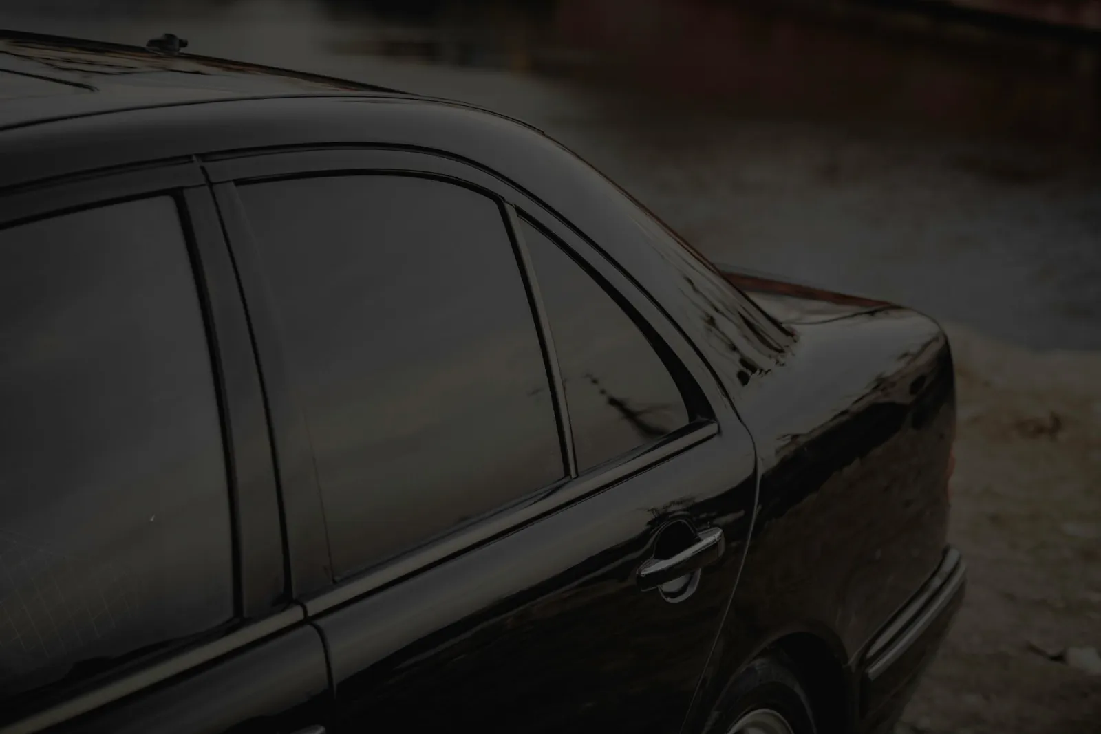 close-up of a car side window showing peeling and discolored window tint film